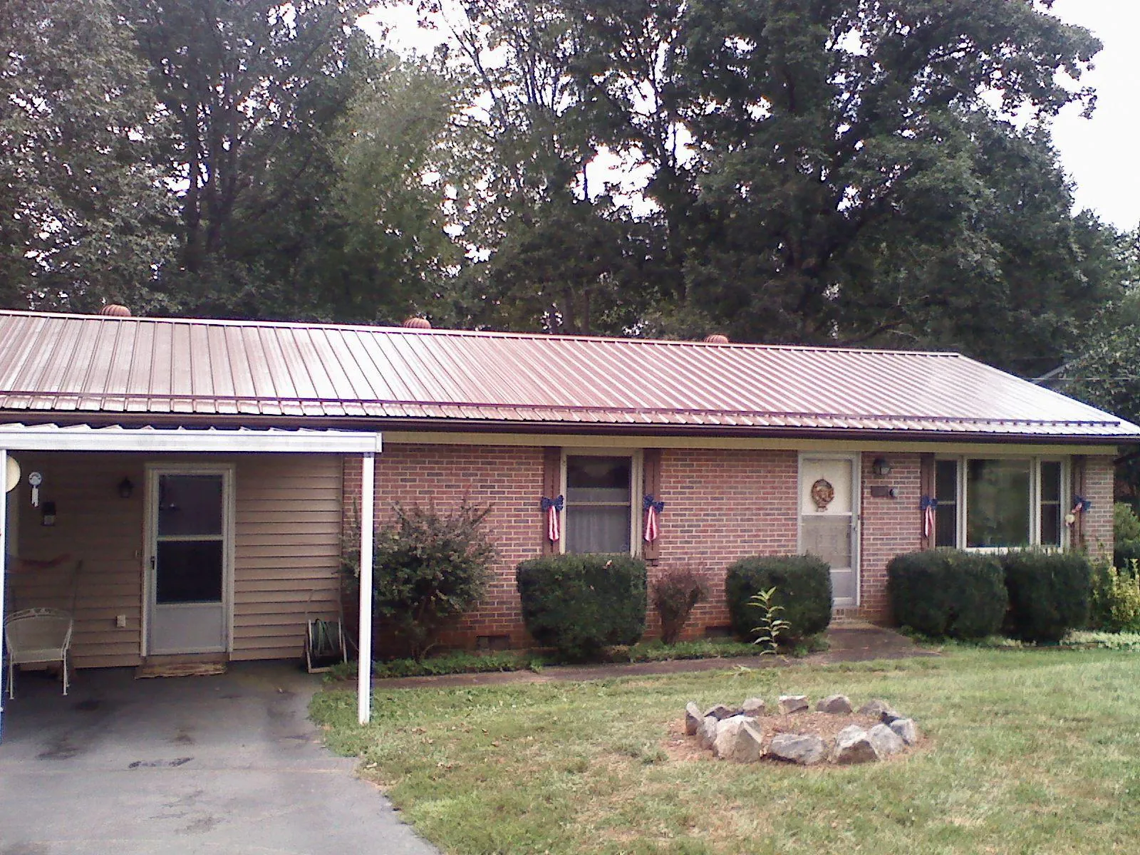 Bronze metal roof and carport on a brick ranch home — Roof Repair work by our crew in Mehama